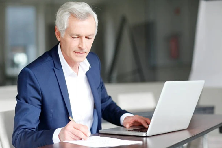 Side view of young engineer in workwear using digital tablet