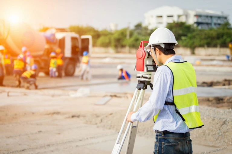 Side view of young engineer in workwear using digital tablet