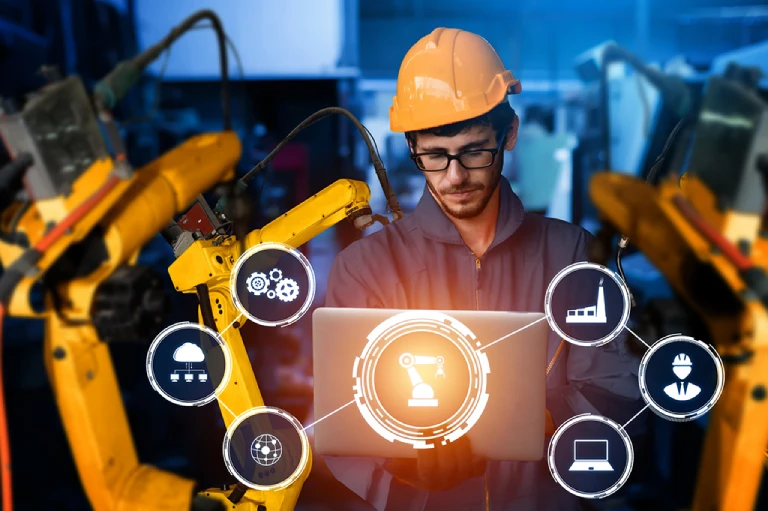 Side view of young engineer in workwear using digital tablet